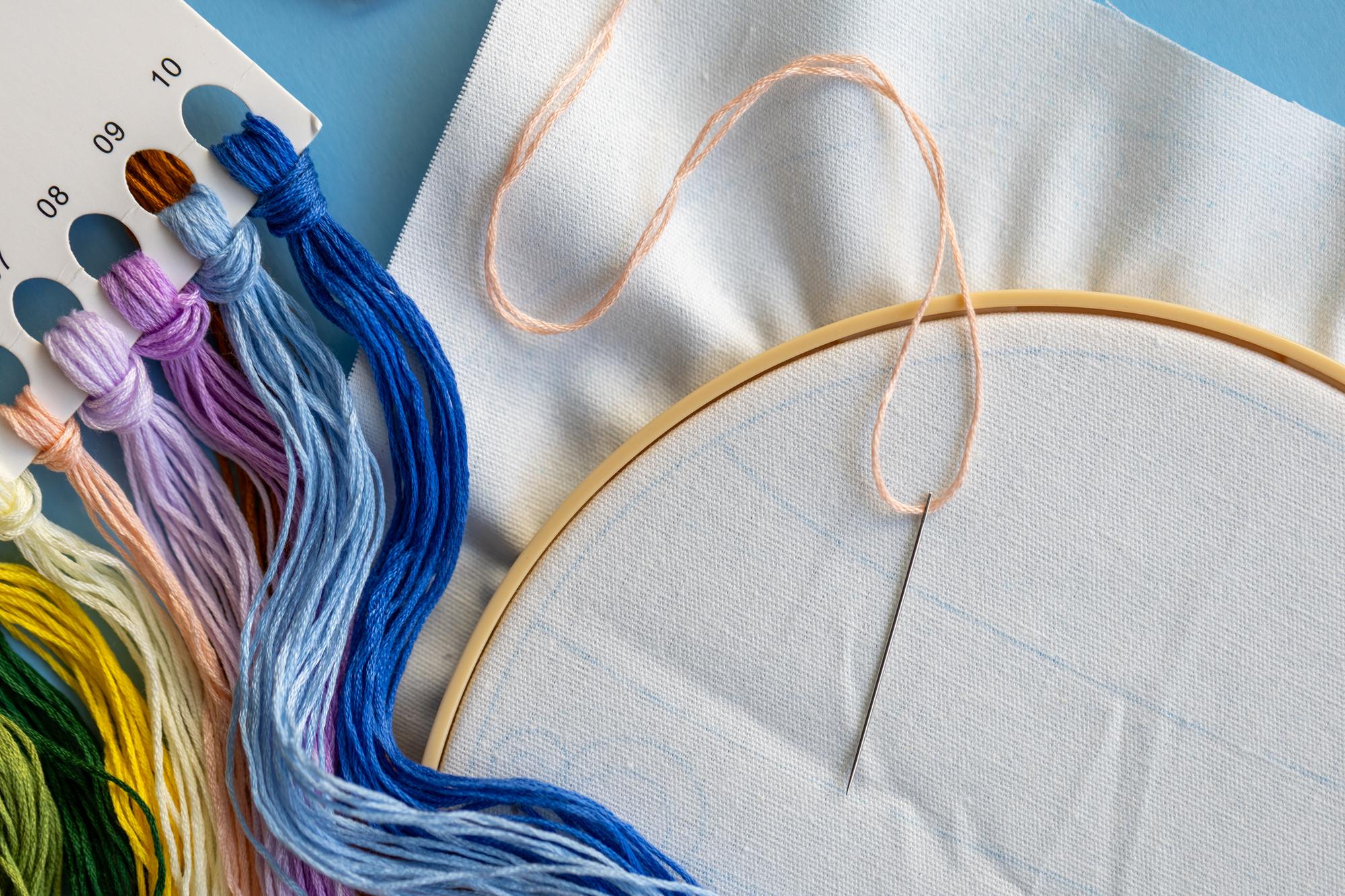 Close-up of hand embroidery on linen with colourful threads